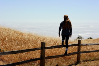 woman jump on brown fence