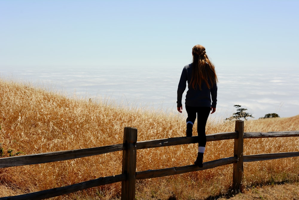 woman jump on brown fence