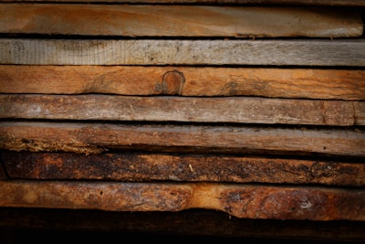 Close-up of rich, textured wooden planks stacked neatly in warm earthy tones.