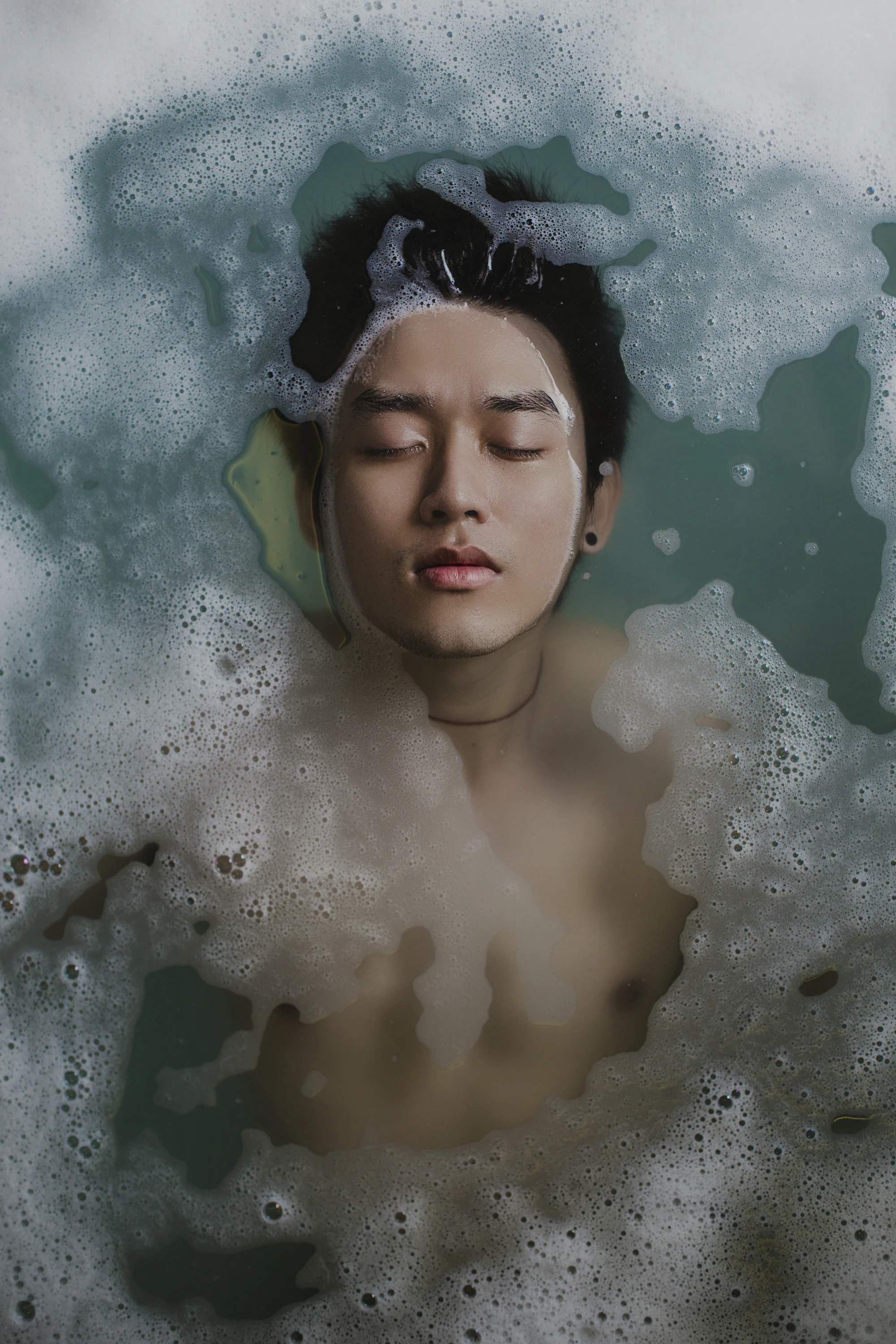 A person resting with eyes closed in cool water