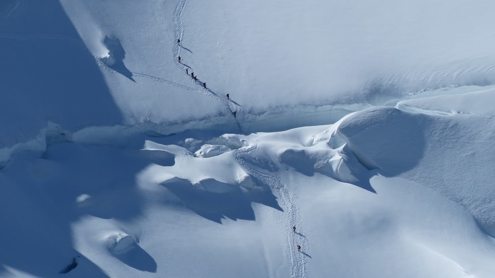 Photographie aérienne d’un groupe de personnes faisant du trekking sur la neige
