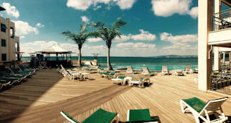 Private wooden deck with sun loungers and umbrellas overlooking crystal-clear Mediterranean waters.