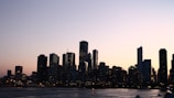 A city skyline with financial district buildings at sunset.