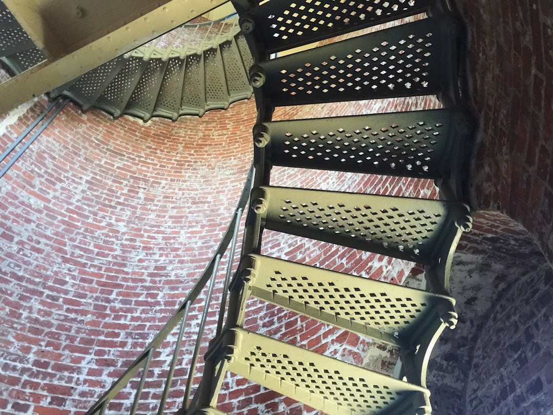 brown wooden spiral staircase with black metal railings