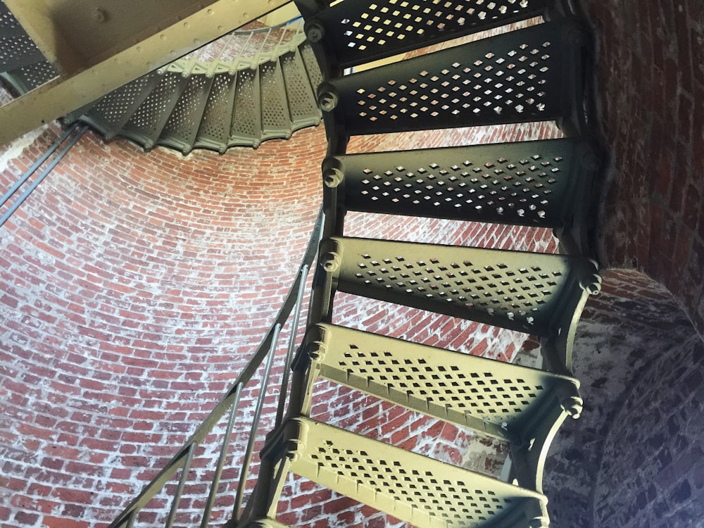 Escalier en colimaçon en bois brun avec rampes en métal noir