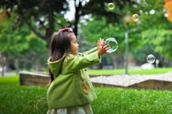 selective photo of a girl holding bubbles