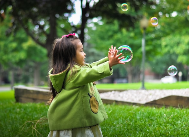 selective photo of a girl holding bubbles