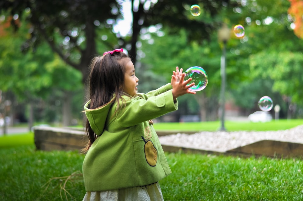 foto selectiva de una niña sosteniendo burbujas