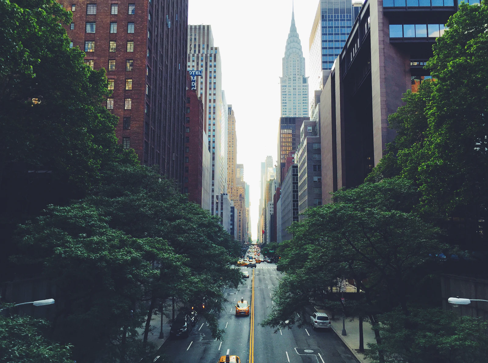 A Midtown Manhattan street with tall buildings rising above it