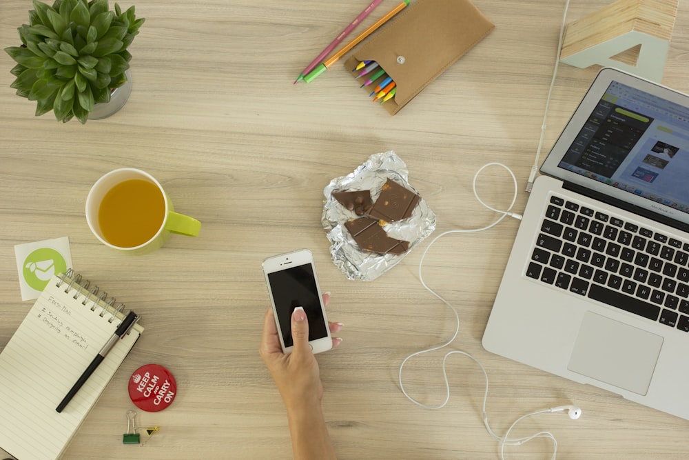 personne tenant un iPhone 5s blanc