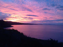 A beautiful sunset view over Ayvalik's coastline with vibrant orange and pink hues.