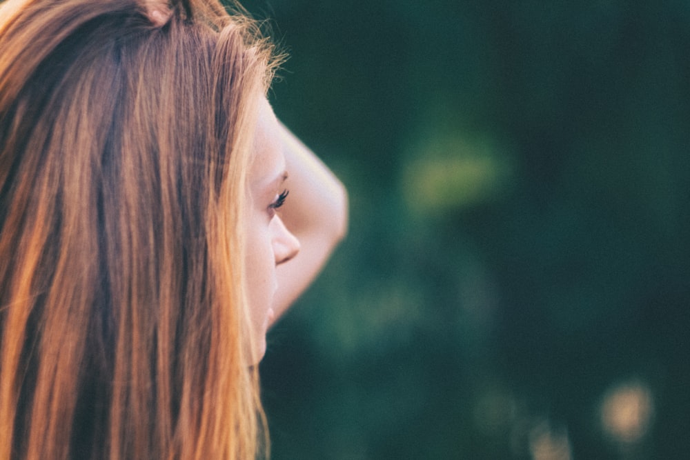 selective focus of woman holding her head at daytime