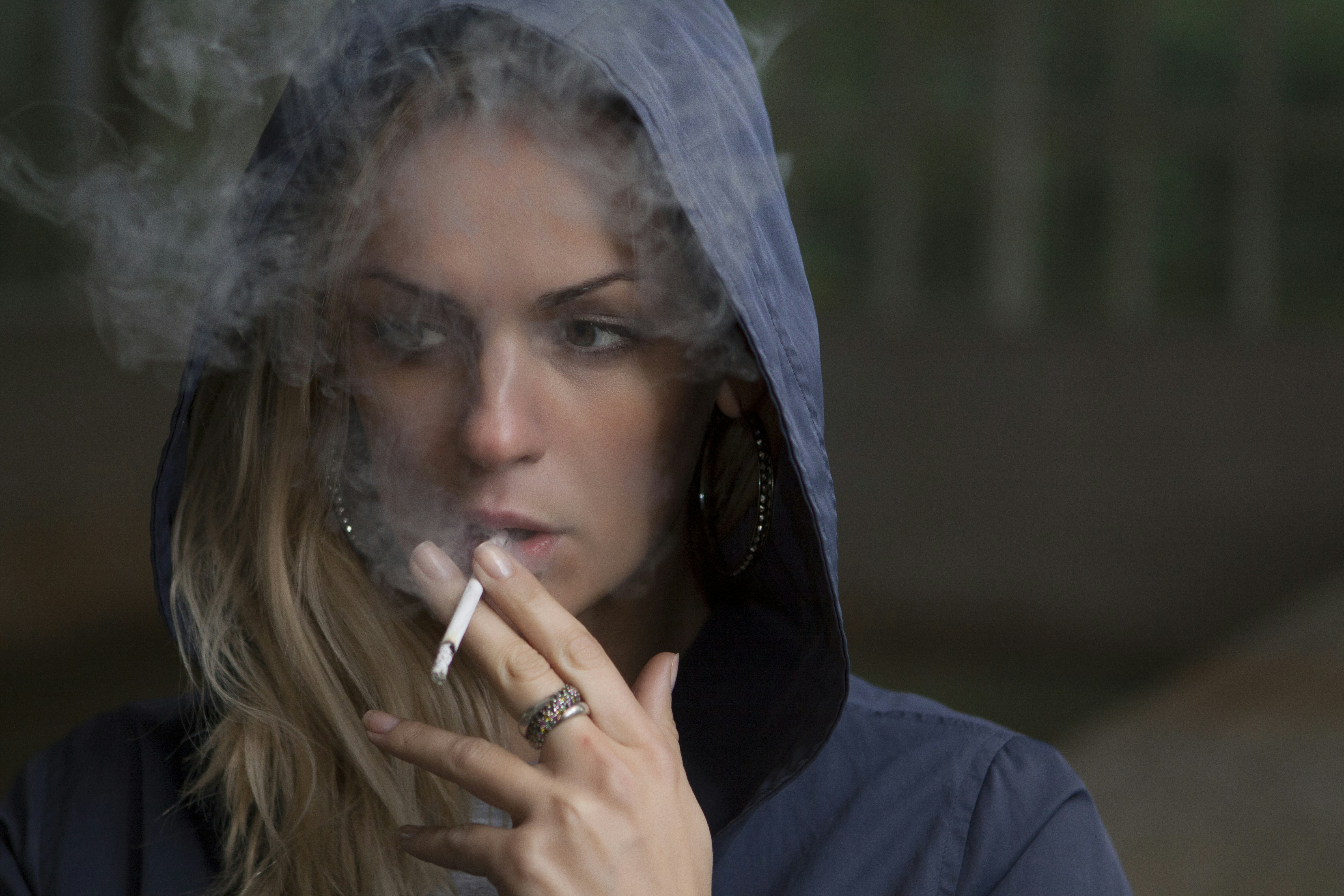 Woman in hoodie smoking