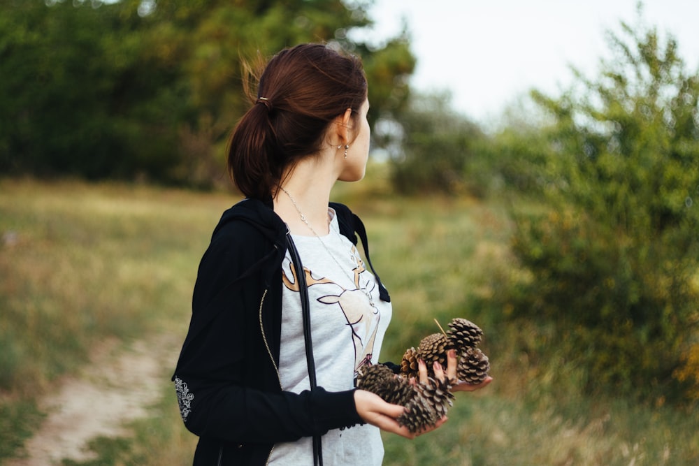 woman holding pinecones