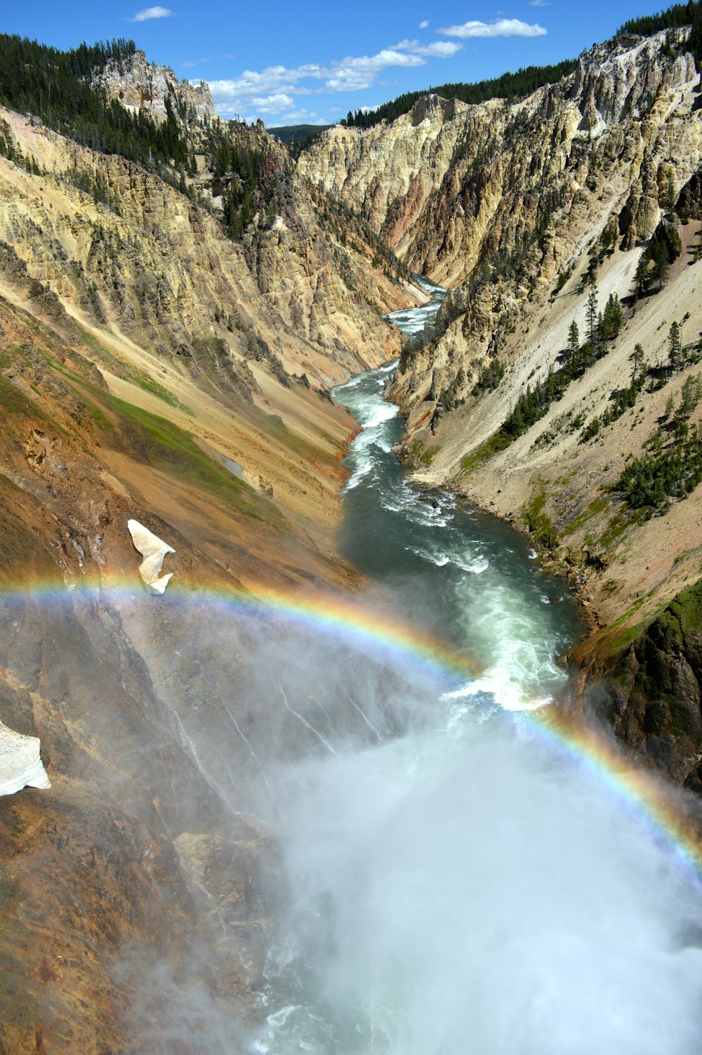 aerial photography of narrow river with forming rainbow