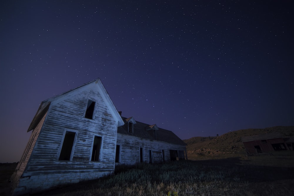 maison sur le terrain sous le ciel avec des étoiles