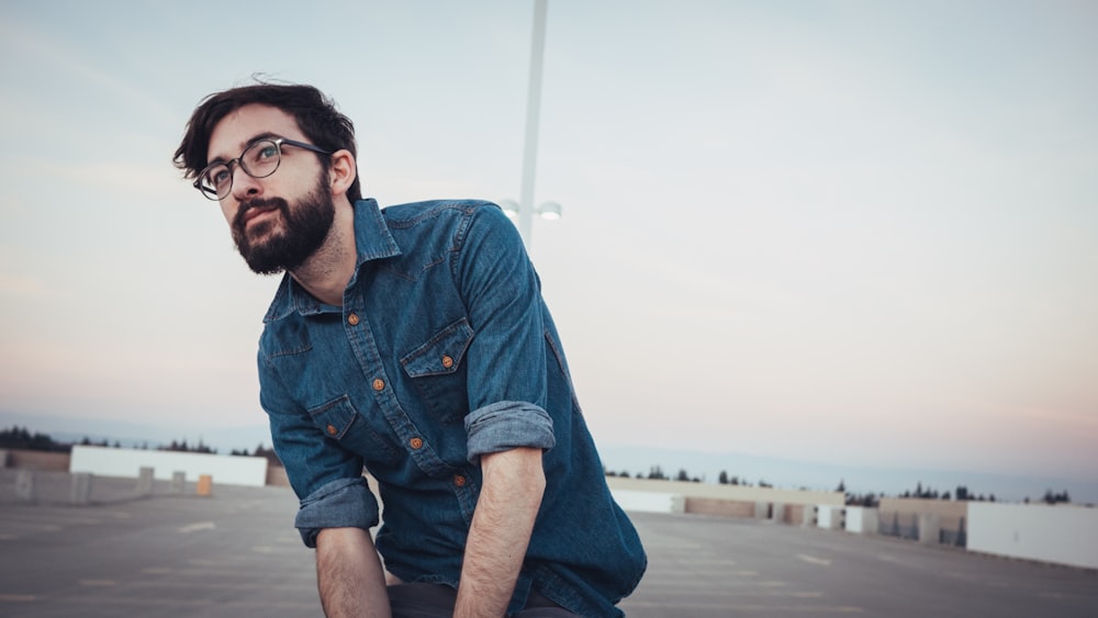 man wearing denim sport shirt and sunglasses on concrete flooring