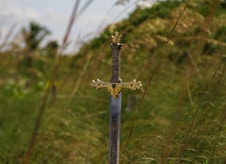 gray steel sword on ground during daytime