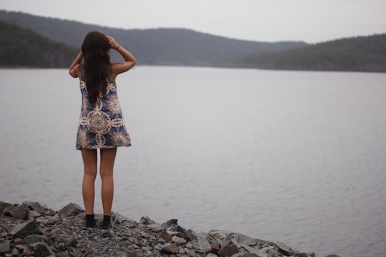 woman standing near water in Hinze Dam Australia