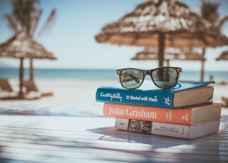 black framed Ray-Ban Wayfarer sunglasses on top of book