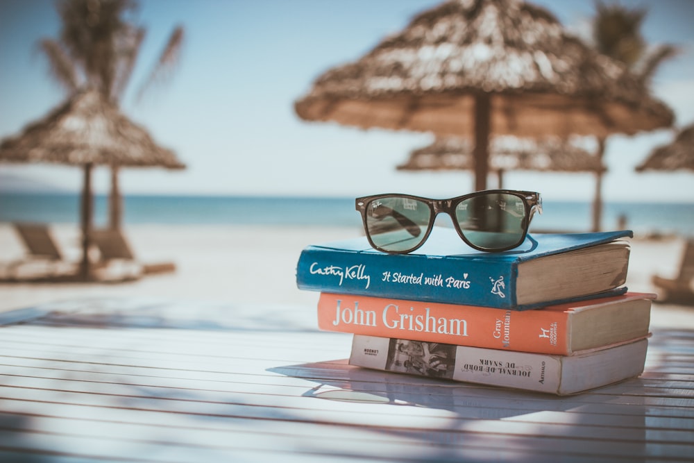 black framed Ray-Ban Wayfarer sunglasses on top of book