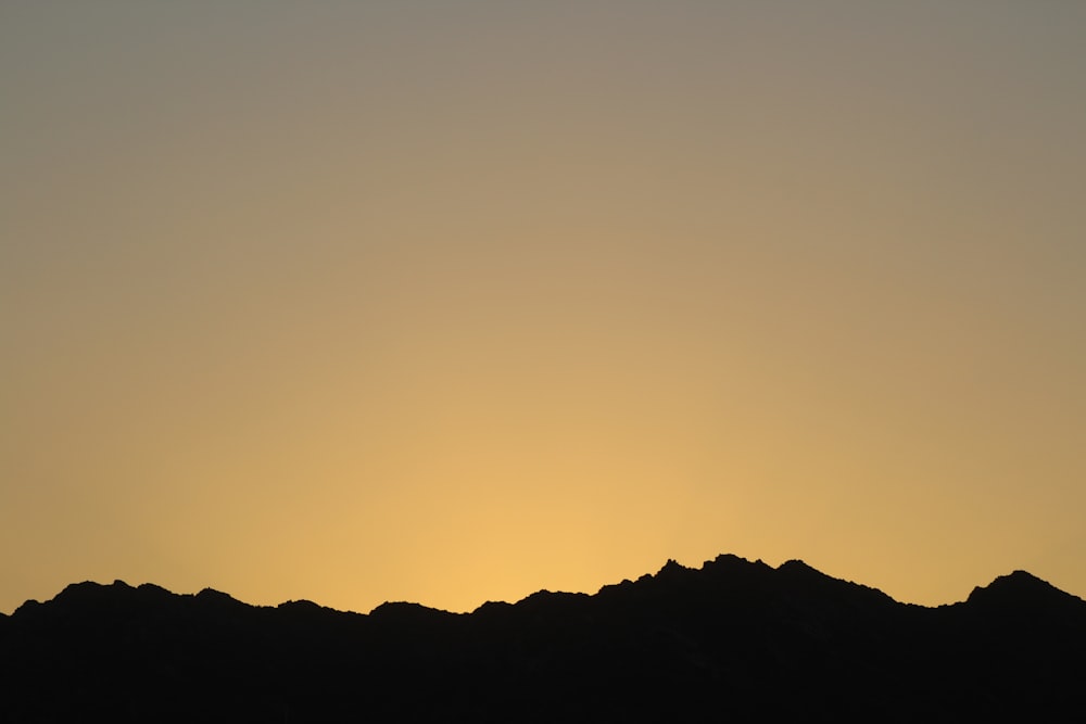 silhouette of mountains with sunrise background