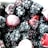 A close-up view of a variety of frozen berries, primarily consisting of blackberries and raspberries, with a light frost covering them.