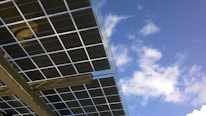 Aerial view of solar panels on a roof under clear blue skies.