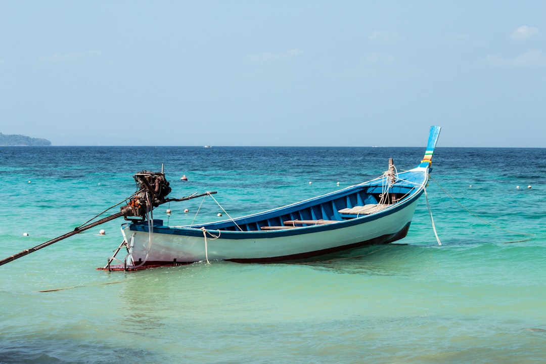 man in brown shirt riding on blue and white boat during daytime