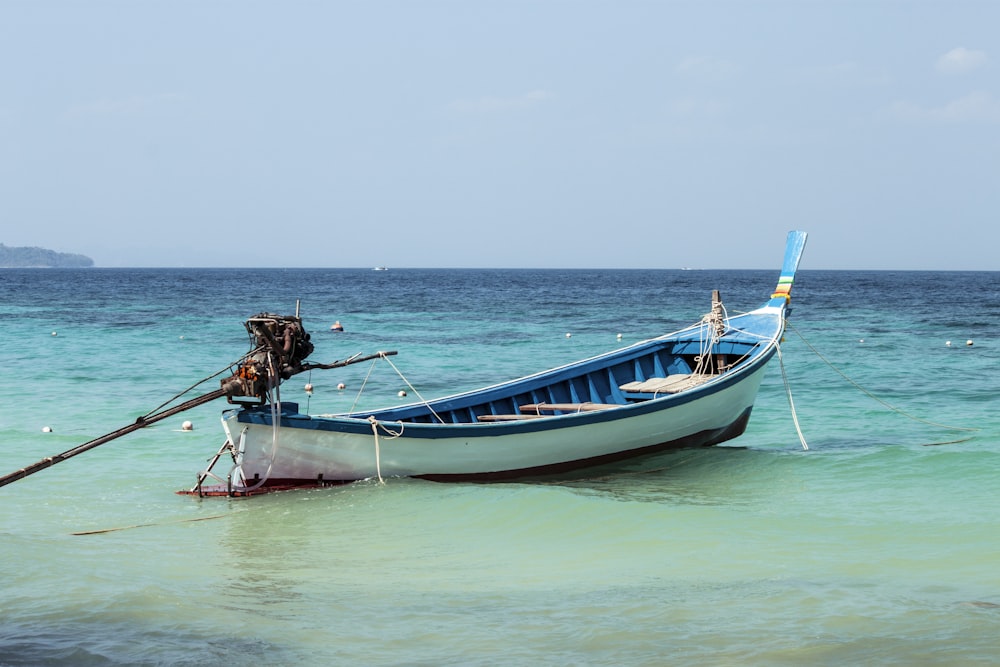 man in brown shirt riding on blue and white boat during daytime