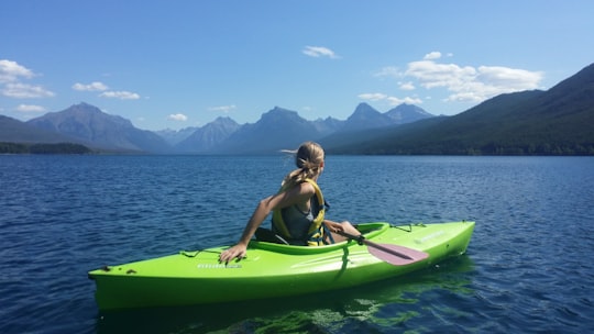 woman on kayak in the middle of body of water in Glacier National Park United States