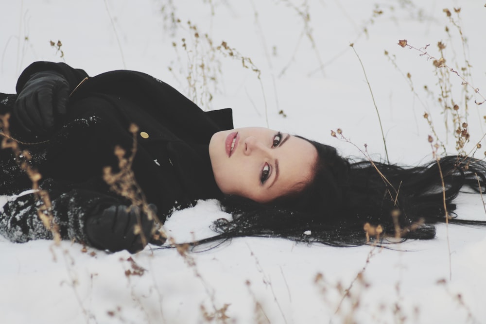 mujer acostada en suelo nevado