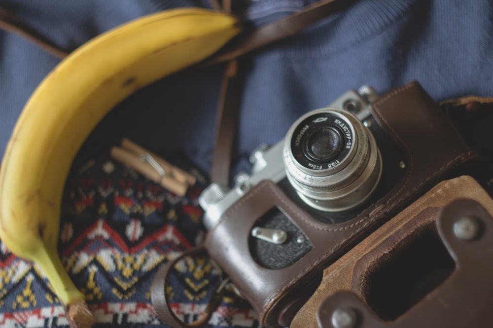 selective focus photography of camera beside banana