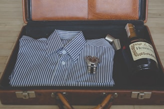 watch, whisky bottle and sport shit in suitcase