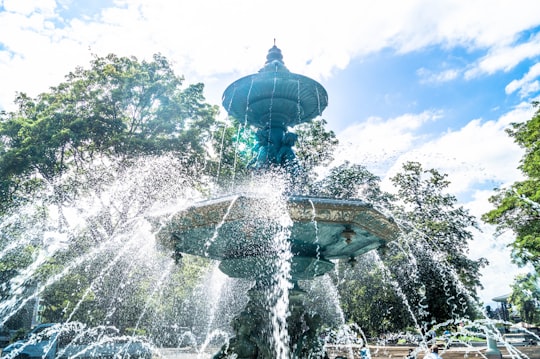 shallow focus photo of outdoor fountain under white and blue cloudy sky in Geneva Switzerland