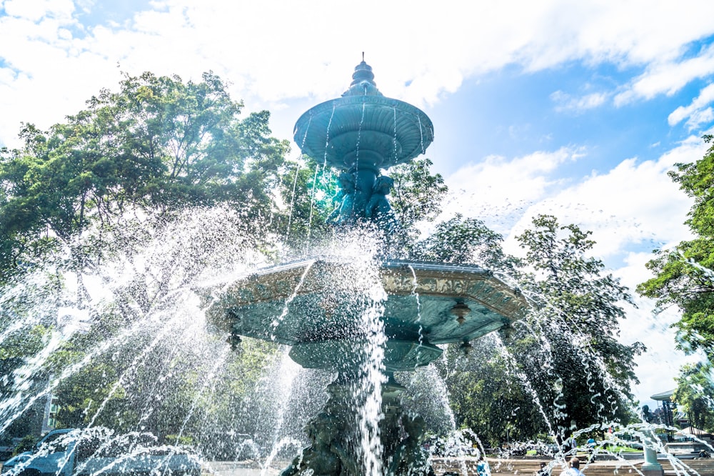 shallow focus photo of outdoor fountain under white and blue cloudy sky