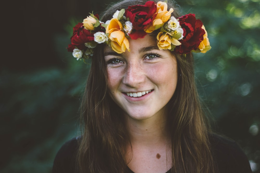 꽃 머리 장식을 착용 한 웃는 여자의 선택적 초점 사진