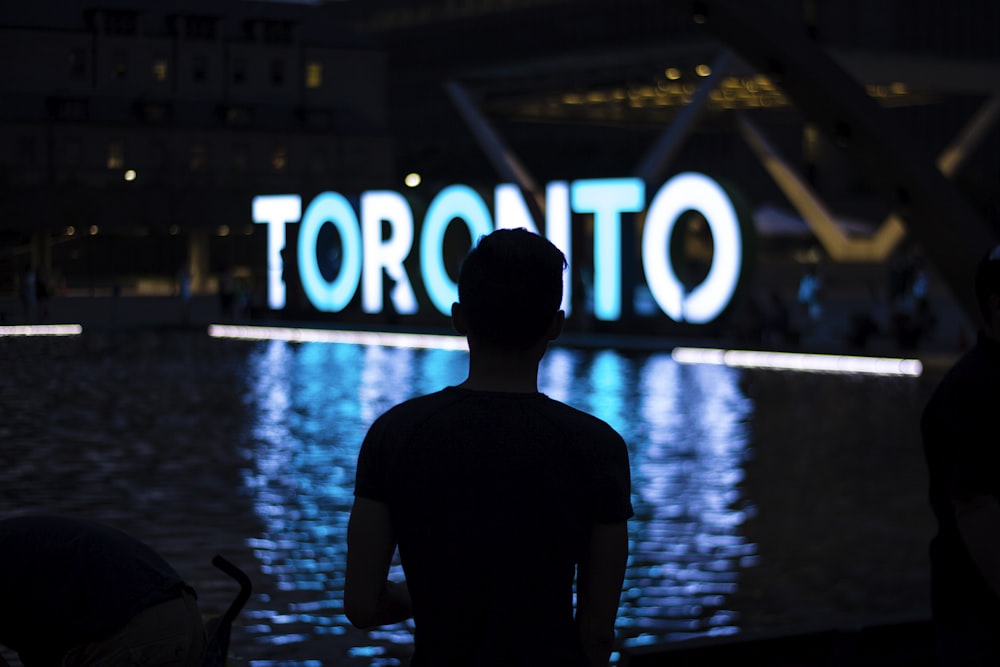 uomo di fronte alla segnaletica a LED di Toronto