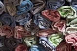 Close-up of colorful fabric rolls stacked in a textile workshop.