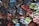 Rows of rolled up fabric are neatly stacked, showcasing a variety of colors including blue, red, green, and beige. The fabric appears to have a textured, striped pattern, and is arranged tightly with careful precision.