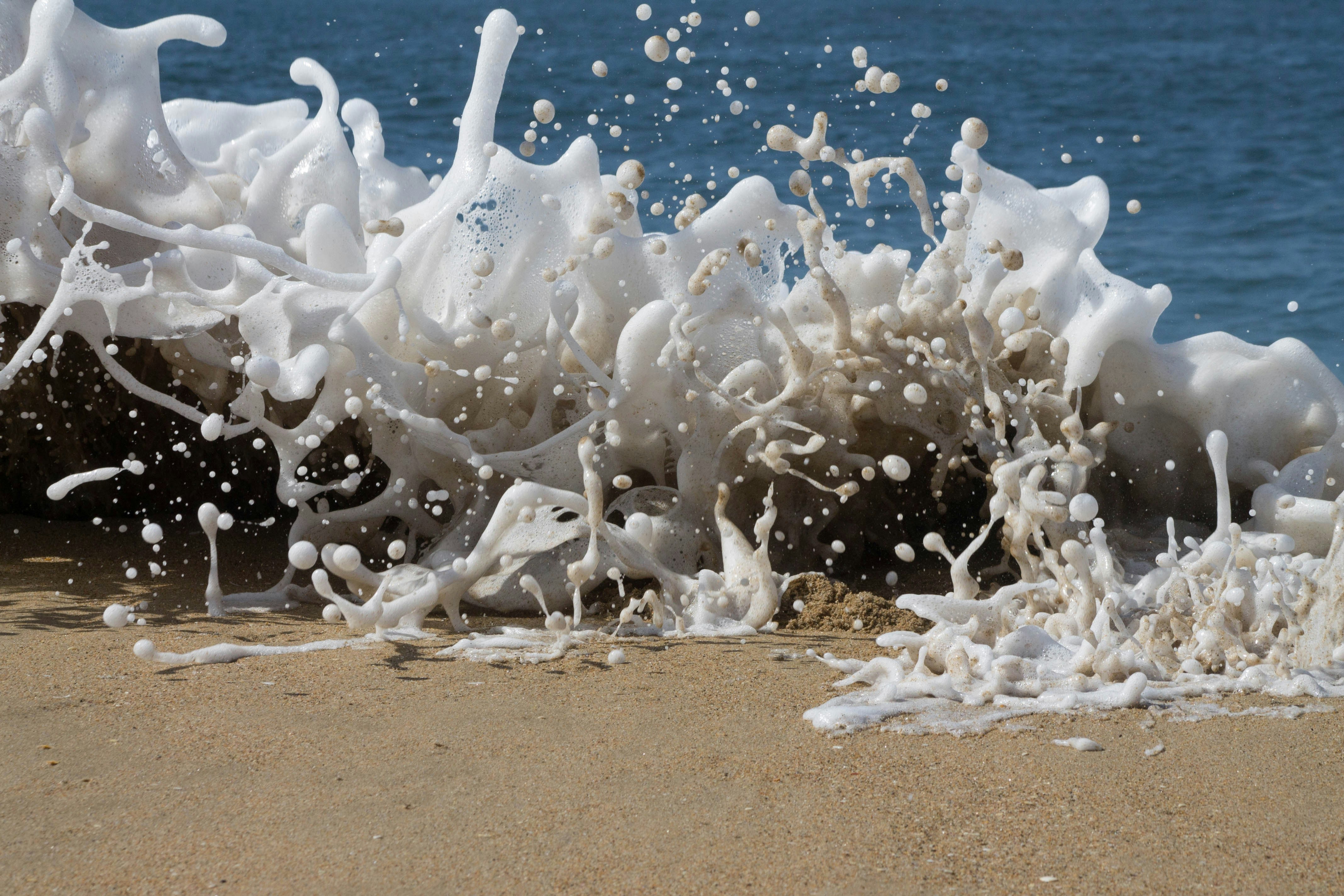 White milky waves hitting the beach sand.