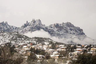 houses near mountain under white clouds
