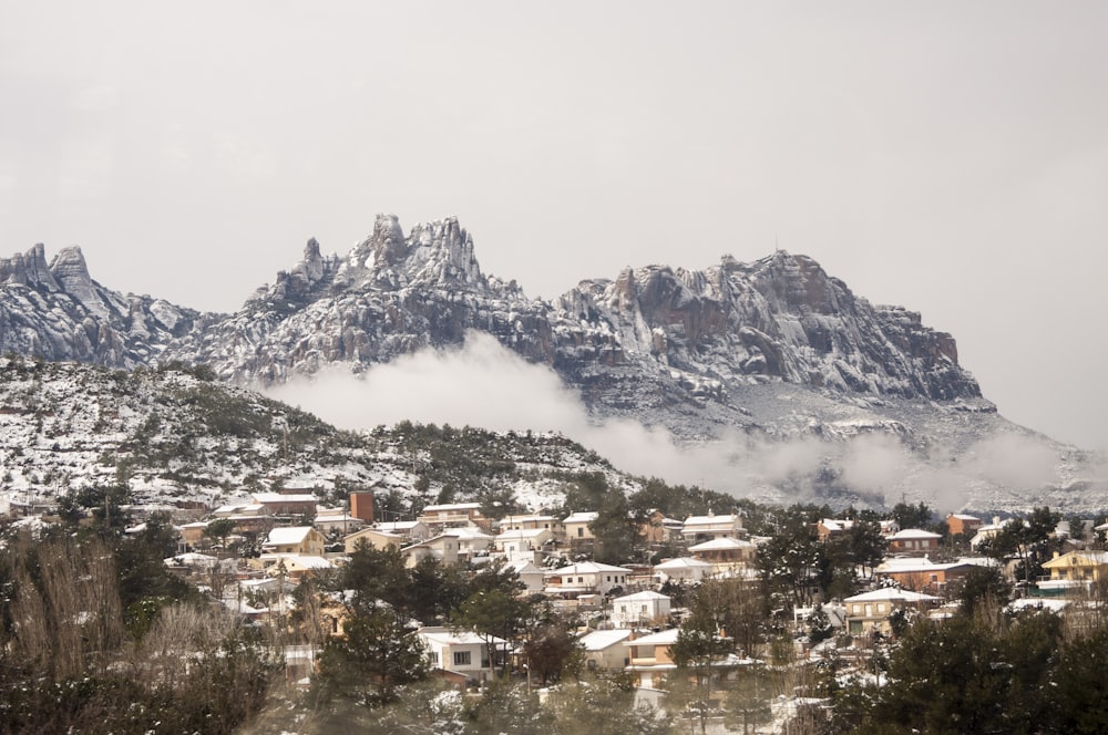 Casas perto da montanha sob nuvens brancas