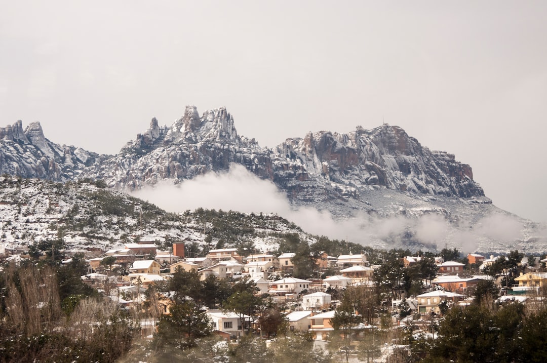 houses near mountain under white clouds