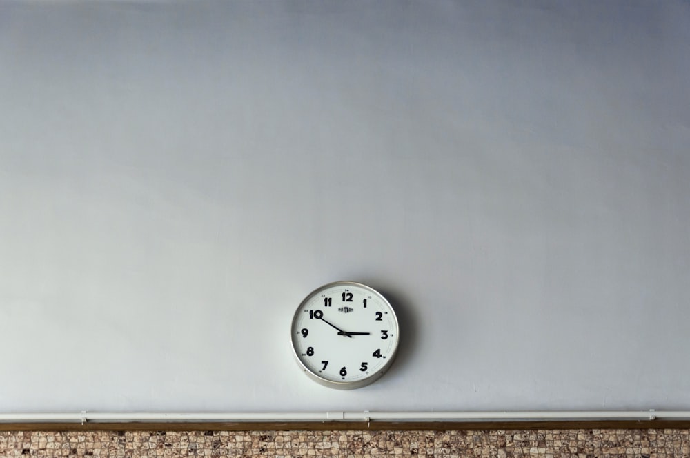 Horloge murale blanche ronde lisant à 2h50