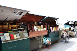 An old Marcus Publishers sign hanging above a bustling book market stall.