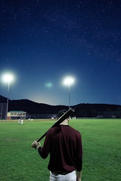 A dynamic baseball player swinging a bat under stadium lights during an intense game.