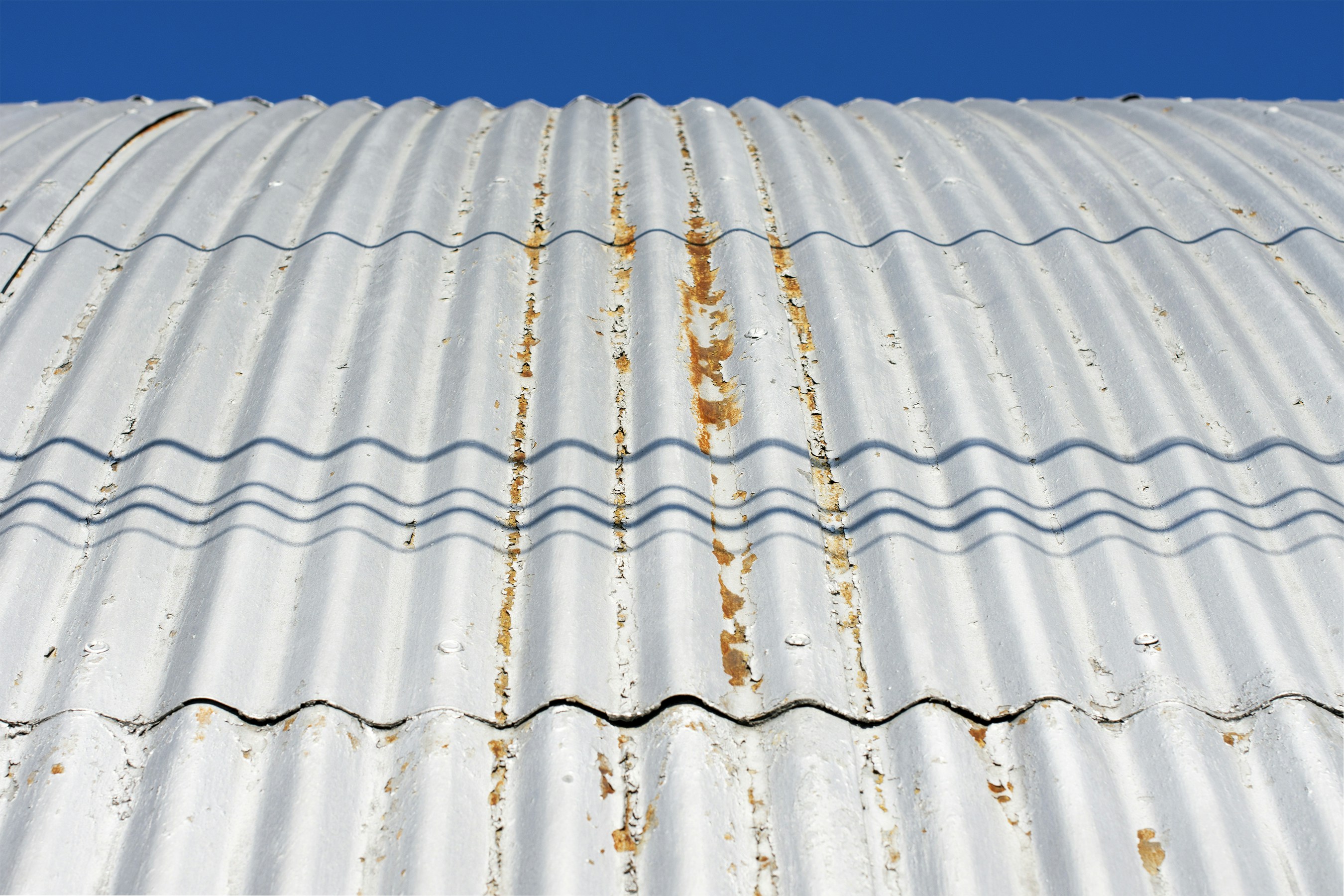 Close-up of a lightweight corrugated roofing sheet with deep wave profile under sunlight.