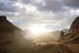A group of hikers pausing on a mountain ridge, overlooking a valley at sunrise.