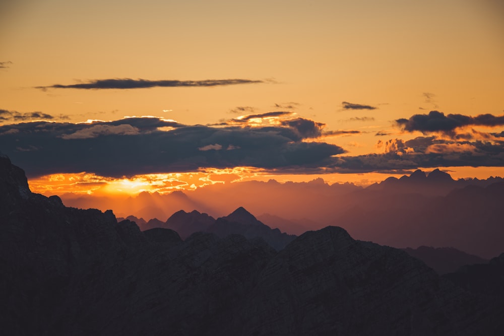 silhouette de photographie aérienne de montagnes au coucher du soleil